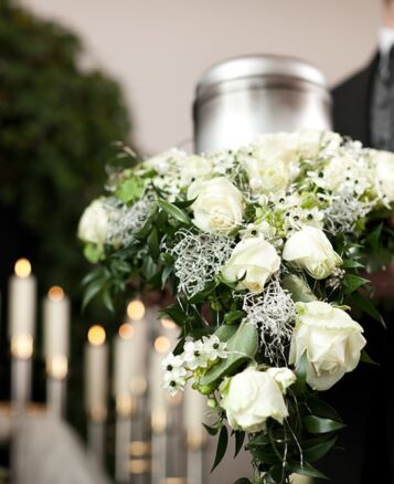 Cremation urn with a bouquet of white roses